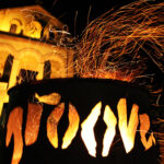 Kirche St. Laurentius in Weinheim am Abend schön beleuchtet. Davor eine leuchtende Laterne, die ausgestanzten Lichtdurchlässe bilden das Wort Groove. Sehr stimmungsvolles Bild