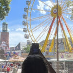 Foto einer Frau die aus dem Schatten eines Torbogens heraus ein Fest fotografiert