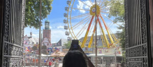 Foto einer Frau die aus dem Schatten eines Torbogens heraus ein Fest fotografiert