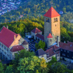 Drohnenaufnahme der Wachenburg in Weinheim. Außenrum Wald und Häuser zu sehen