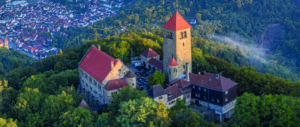 Drohnenaufnahme der Wachenburg in Weinheim. Außenrum Wald und Häuser zu sehen